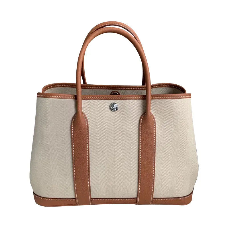 Women's canvas crossbody tote bag with leather trim in bucket shape showing internal organisation pockets.