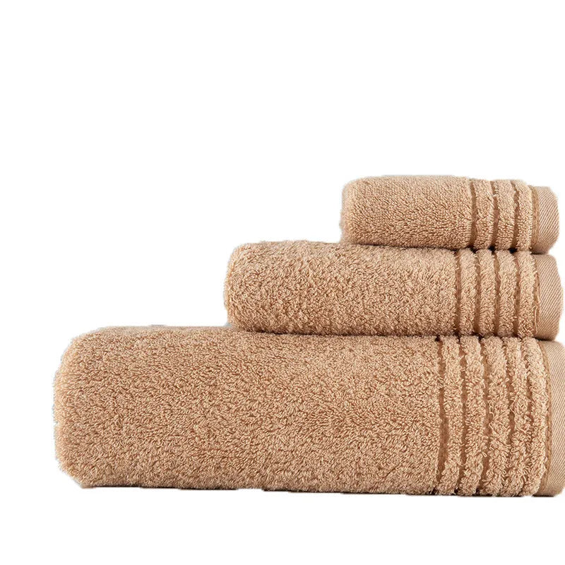 Set of three cotton towels in beige and brown including large bath towel, hand towel, and small washcloth