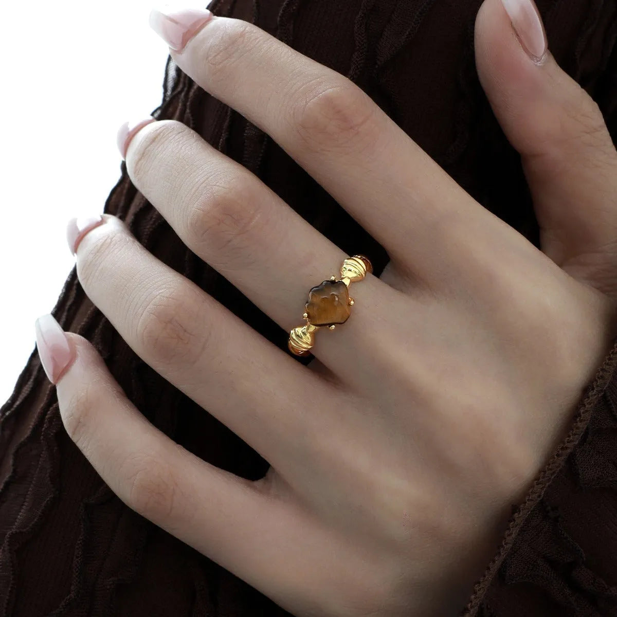 Adjustable silver ring with a white shell and tiger eye stone, featuring an electroplated gold finish.