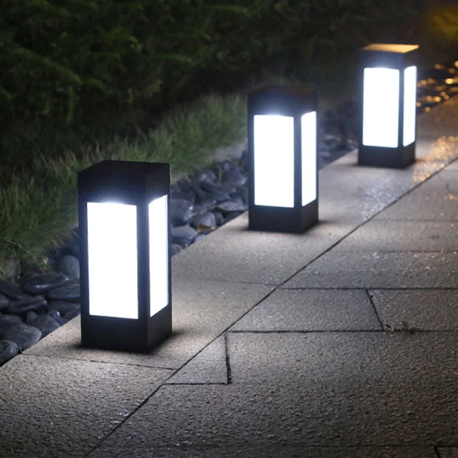 Set of four different styles of solar-powered LED garden lights for outdoor use.