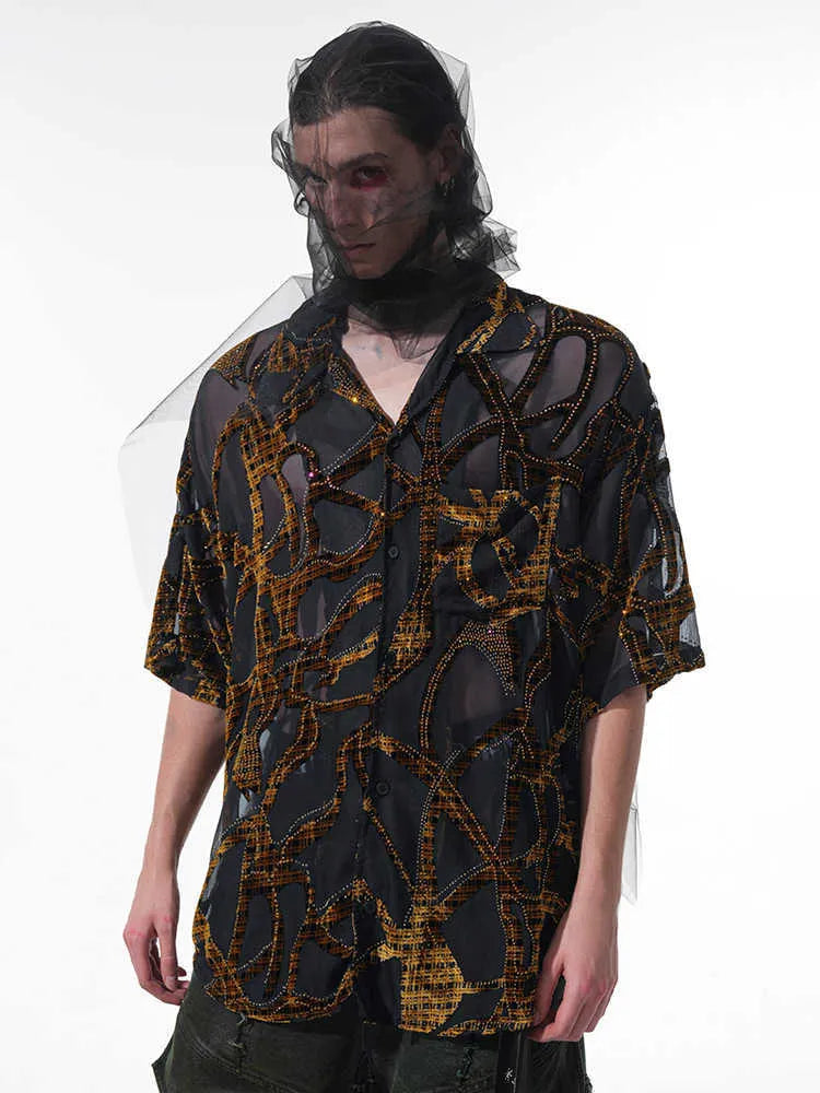Man wearing a black and grey translucent snake pattern short-sleeved shirt with a lapel collar.
