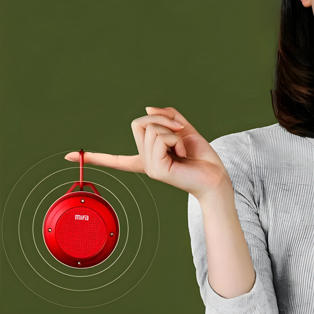 Portable Bluetooth speaker in grey silicone case with button controls, USB port, and compact size