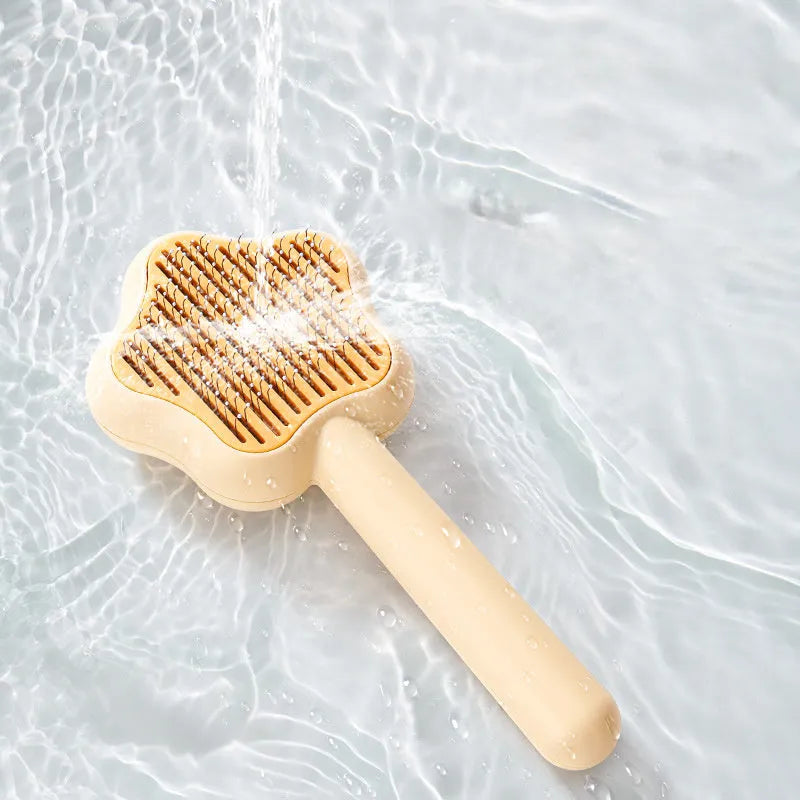 Green self-cleaning stainless steel cat comb for pet grooming on a white background