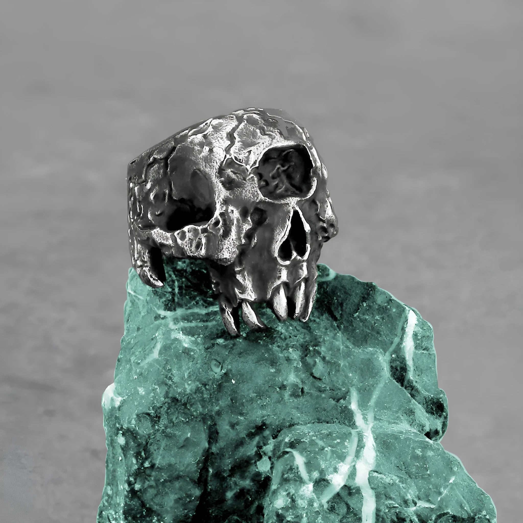 Alloy one-eyed skull ring in a retro electroplated finish, shown on a finger.