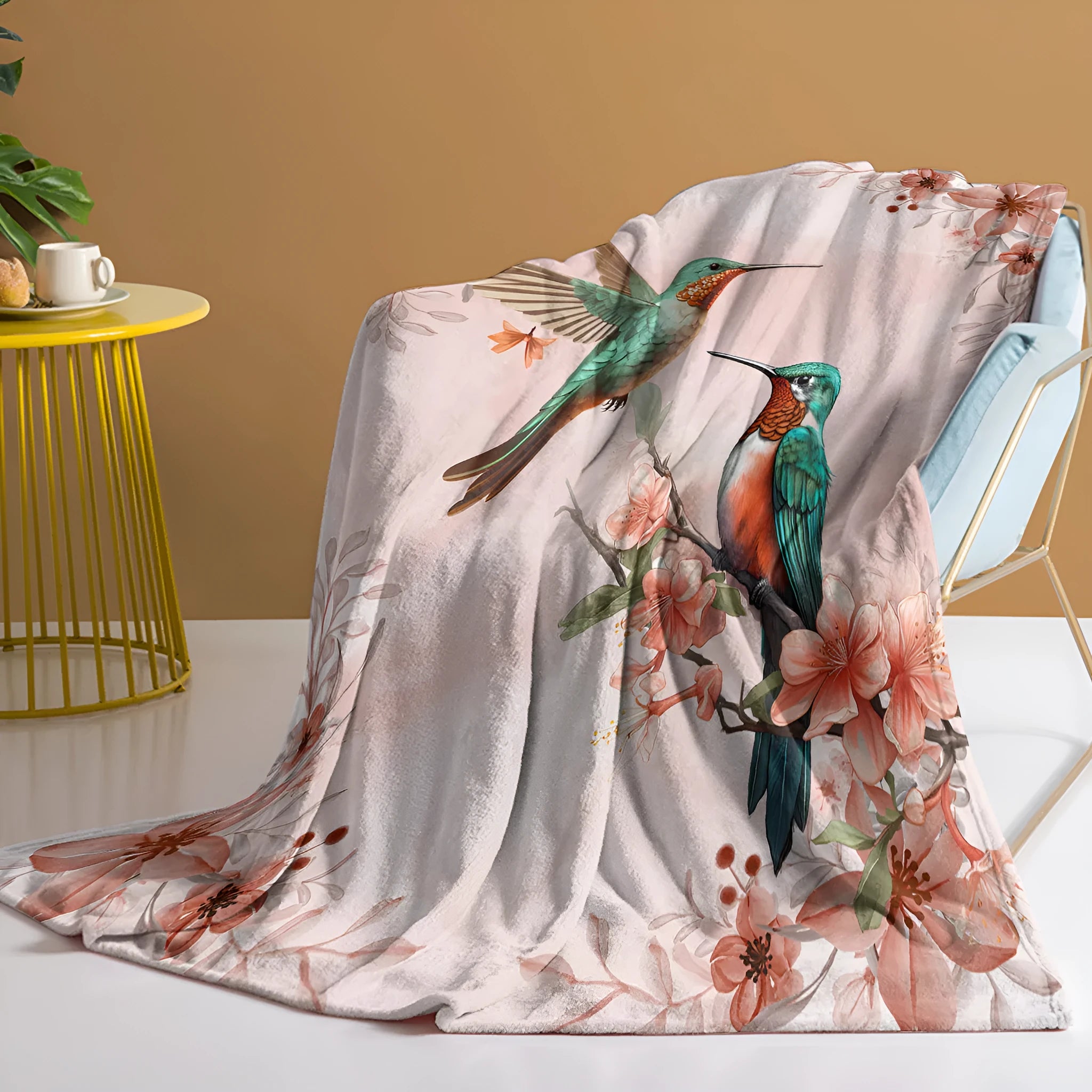 Pink hummingbird floral fleece throw blanket on sofa with floral print