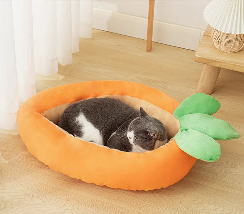 Orange carrot-shaped dog nesting bed with a raised bolster edge and a separate soft blanket, shown in two sizes.