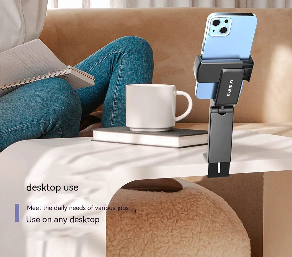 Foldable rotating universal phone holder in black on a desk next to a mobile phone.