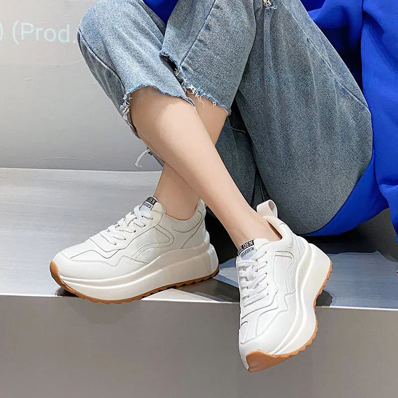 Women's beige low-top casual leather sports shoes with lace-up front and cross-strap detail on a white background