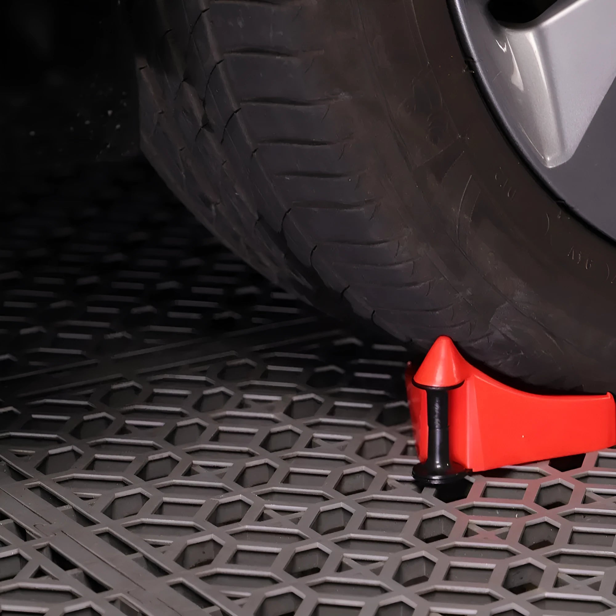 Set of four bright red triangular plastic car parking blocks on a surface.