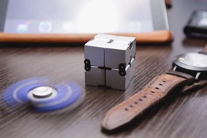 Zinc alloy infinity cube fidget toy showing black and silver colour options, sized at 4cm.