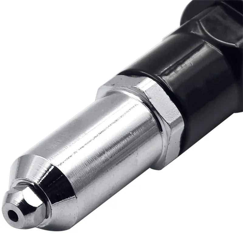 Black metal electric drill rivet gun with handle, wrench, and rivet heads on a workbench.