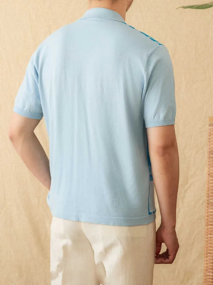 Man wearing a royal blue striped short-sleeved knitted polo cardigan with a lapel collar.