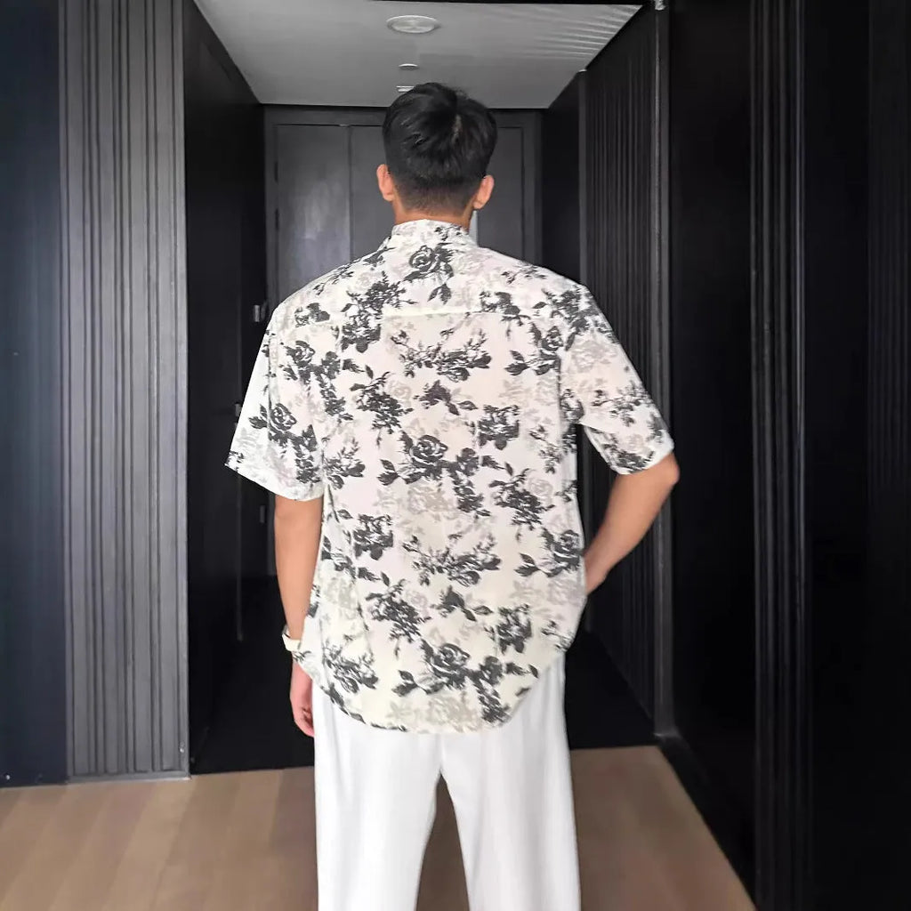 Man's loose black short sleeve shirt with a white floral print pattern.