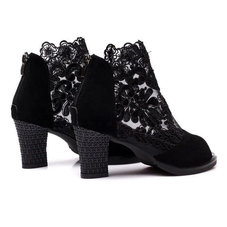Lucyever women's black gladiator sandals with floral lace upper, square heel, and peep toe on a foot.