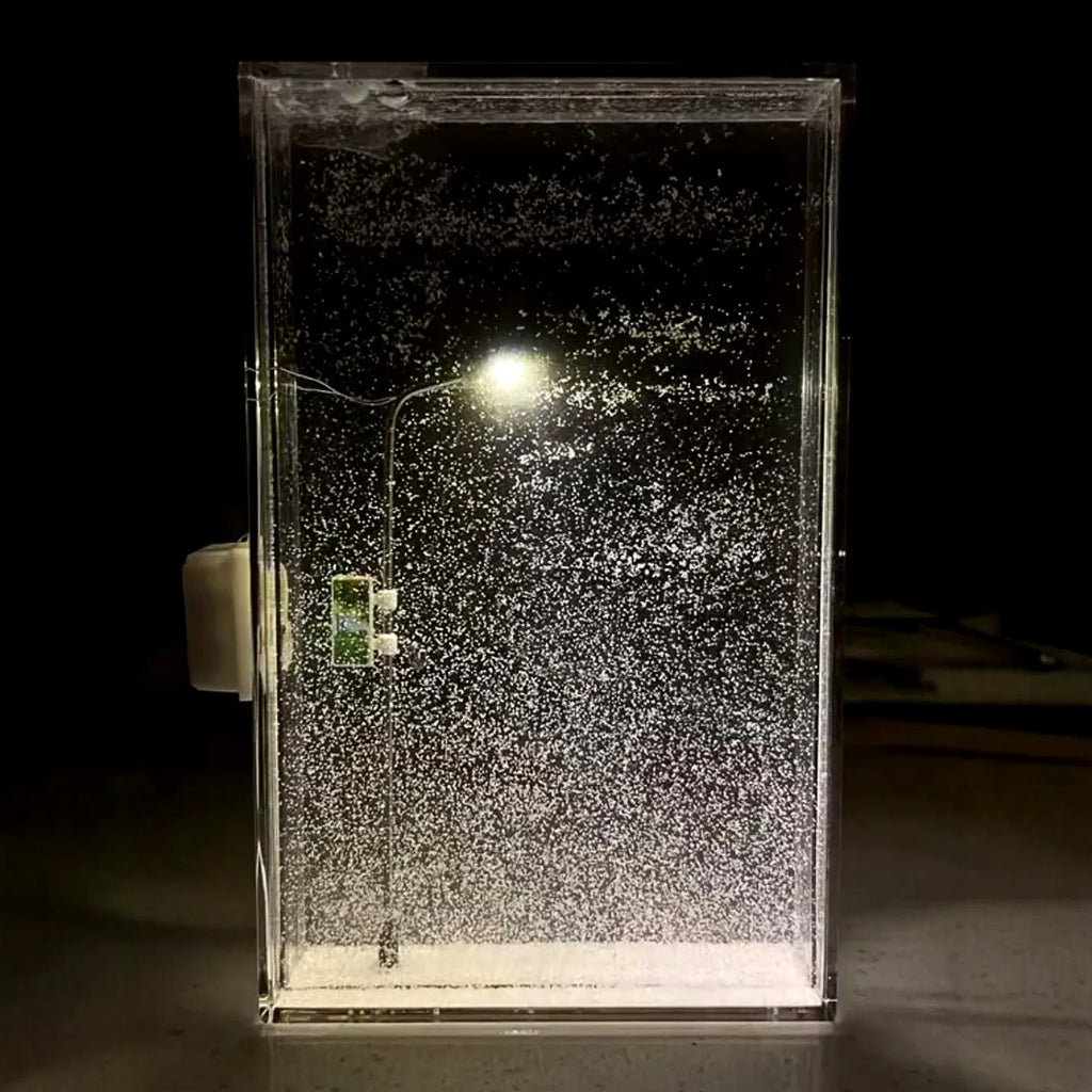 DIY Christmas night light kit showing snowy landscape scene with glowing street light and flowing snow effect