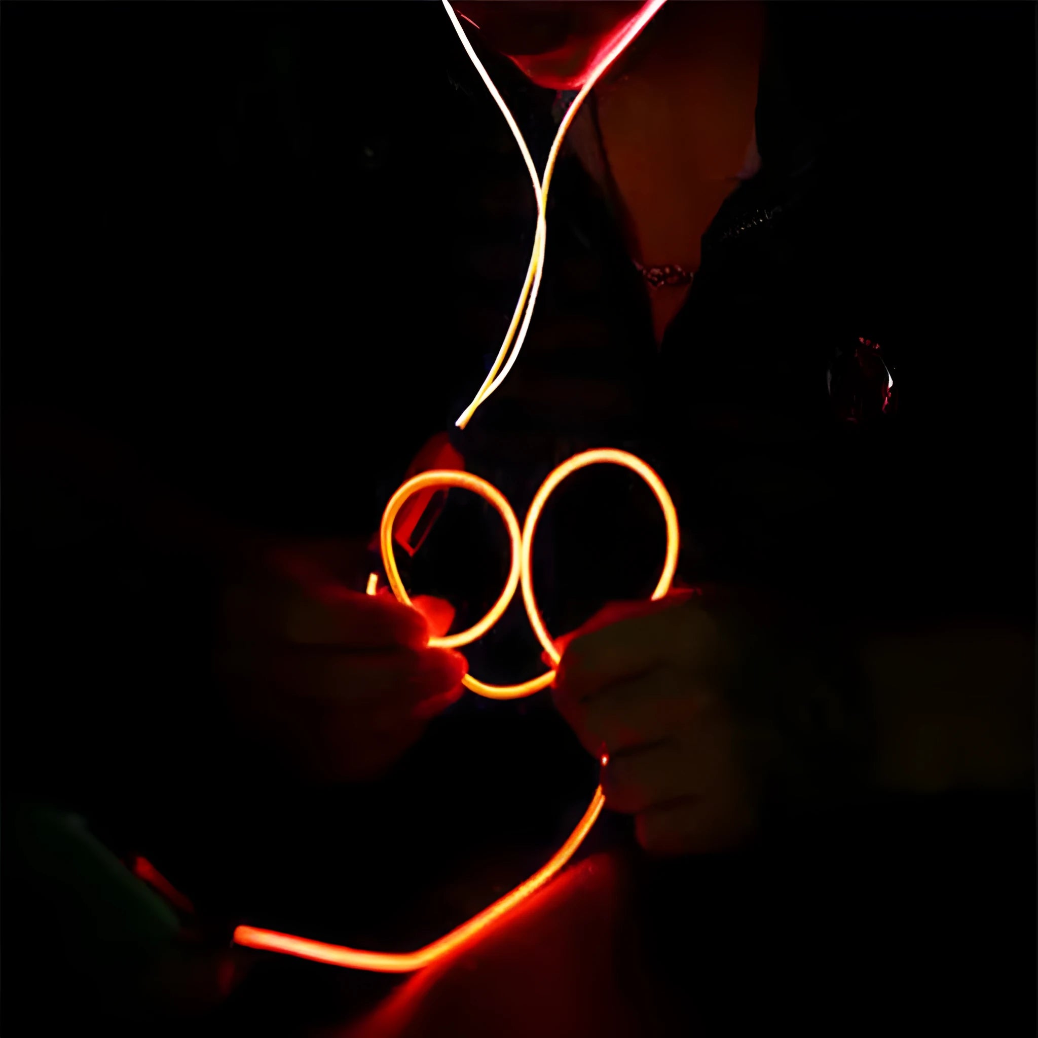 Blue wired LED light-up earphones with 3.5mm plug and inline remote control on a dark background.