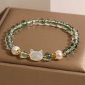 Green phantom quartz bracelet with shell kitten charm on wrist