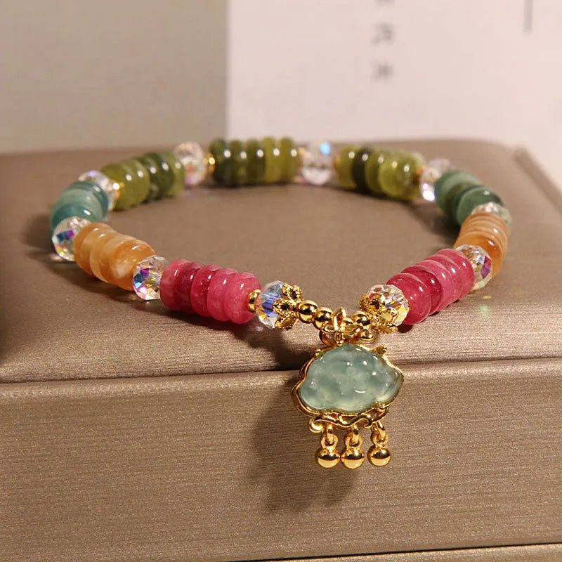 Colorful Tourmaline Jade Xiangyun crystal bracelet with alloy inlay and stone accents on display
