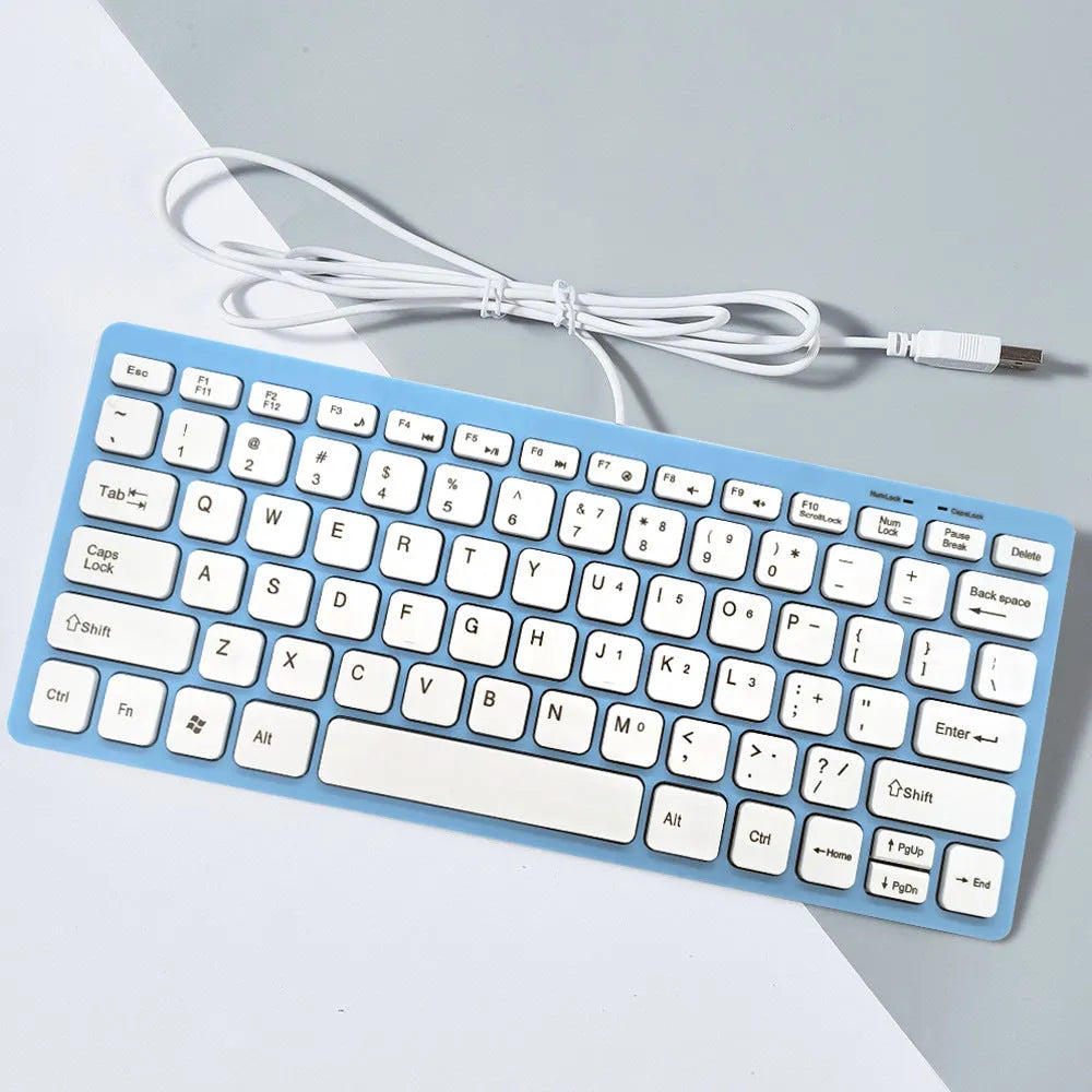 USB wired mini computer keyboard in black, white, pink, or blue colour on a desk.