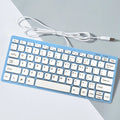 USB wired mini computer keyboard in black, white, pink, or blue colour on a desk.