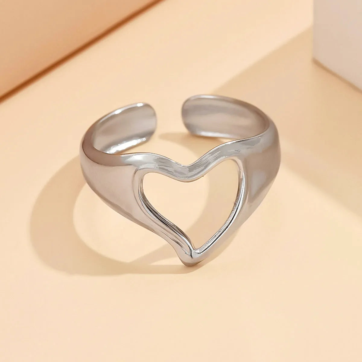 Adjustable hollow heart open ring in stainless steel with U-shaped band and rose motif, shown in steel or gold colour