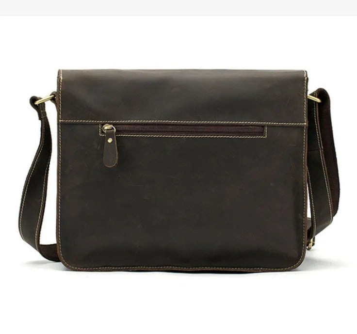 Brown full-grain leather vintage messenger bag with front flap, shown open to reveal internal laptop sleeve and pockets.