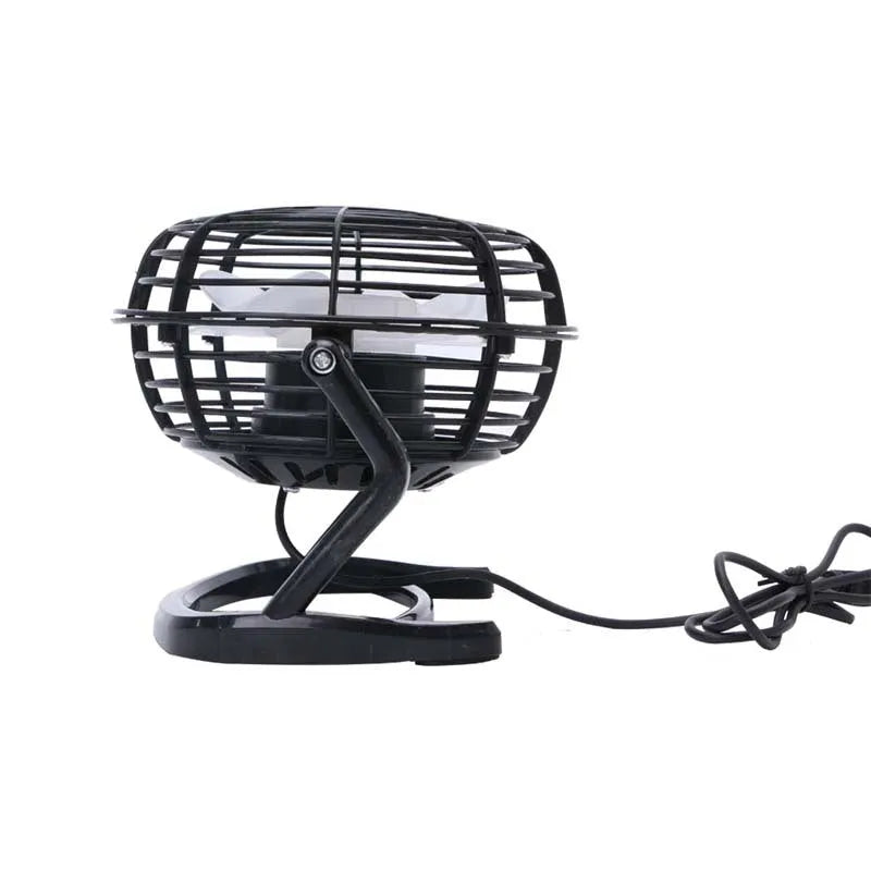 Small black and white USB desktop fan with adjustable stand on a desk next to a laptop.
