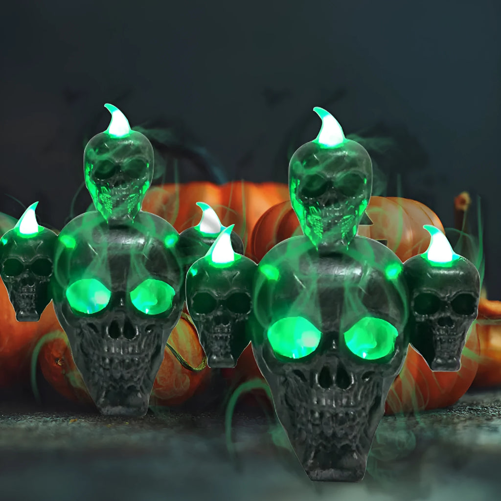 Golden skull ornament with LED light shaped like a skeleton hand holding a candle