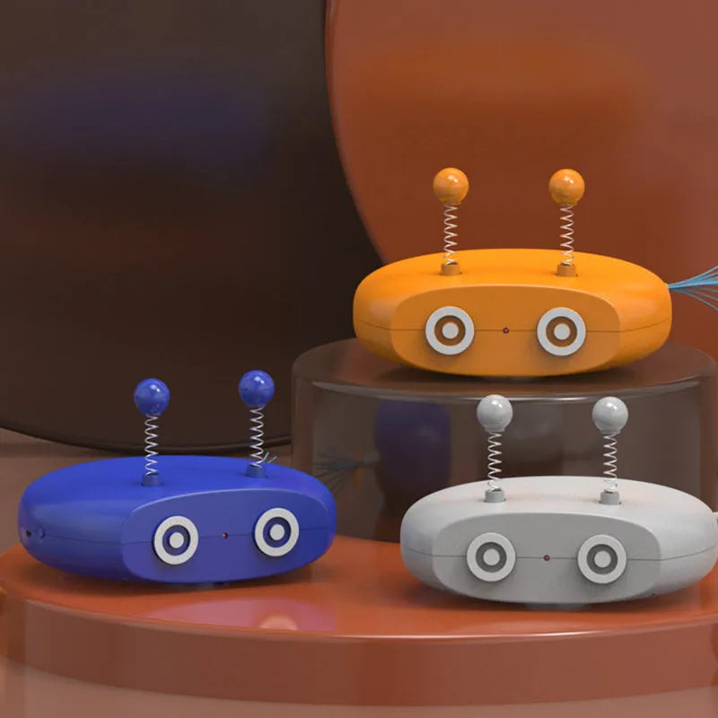 Blue rechargeable robot cat toy with laser pointer and feather attachments on grey floor