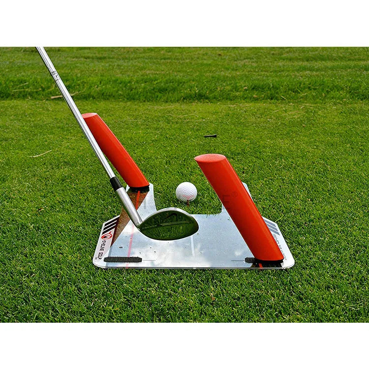 Red plastic putting practice mirror for golf training aid on green surface