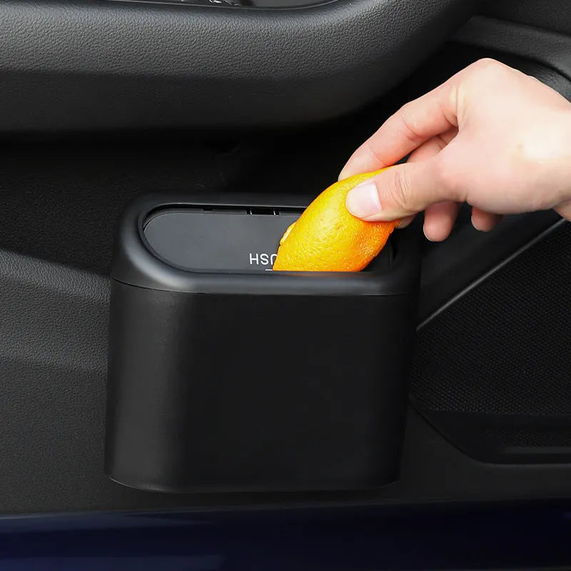 Black ABS plastic car trash can measuring 160x143x85mm with removable hook and upturned lid