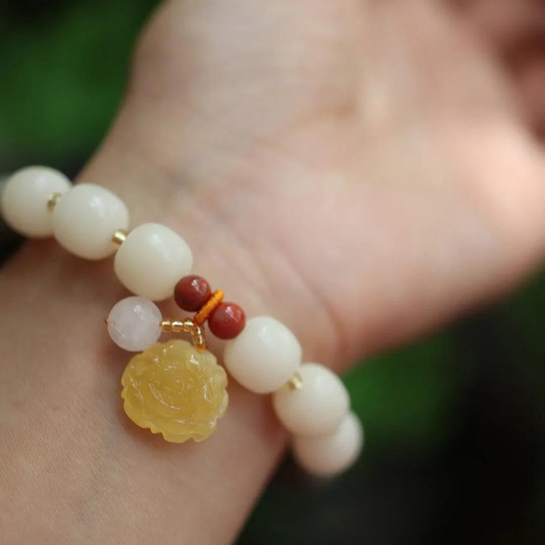 Woven bodhi bracelet with gradient white jade beads and natural beeswax lotus pendant on wrist