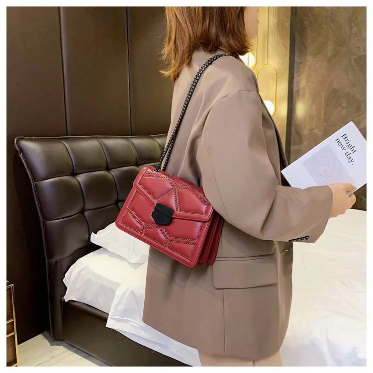 Small square shoulder bag with studs, chain handle, and zipper closure in wine red colour