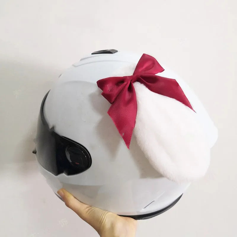 Carbon fibre rabbit ear decoration attached to a black motorcycle helmet, showing clip-on mechanism.