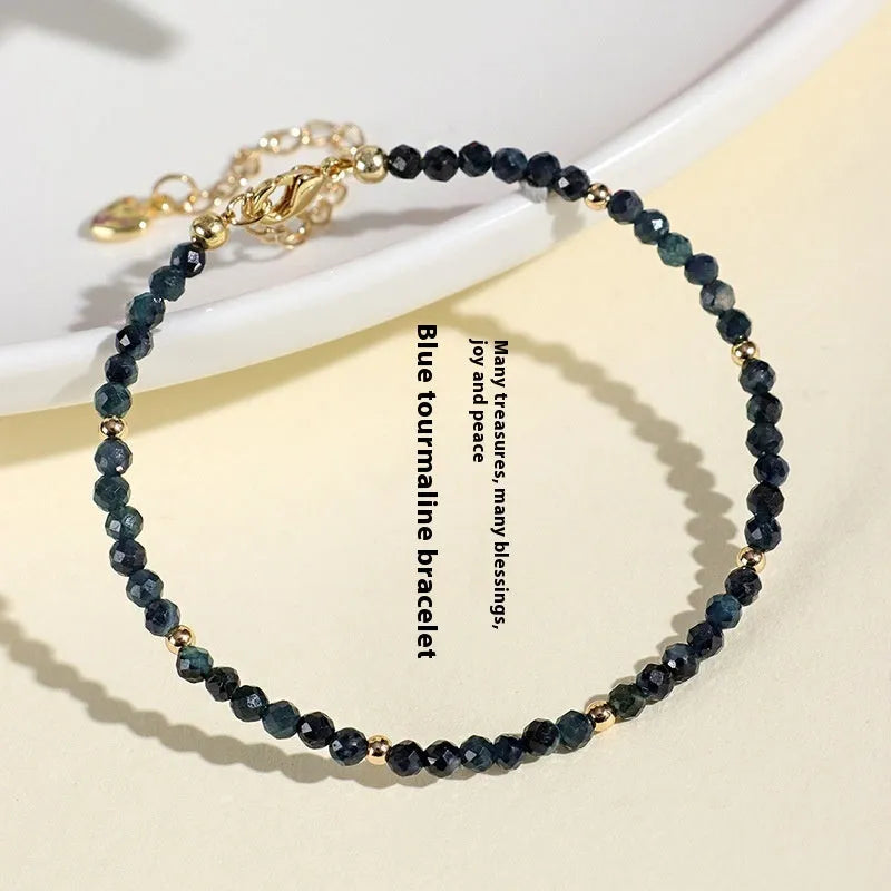 Blue tourmaline bracelet with 3mm beads and silver spacer beads on wrist