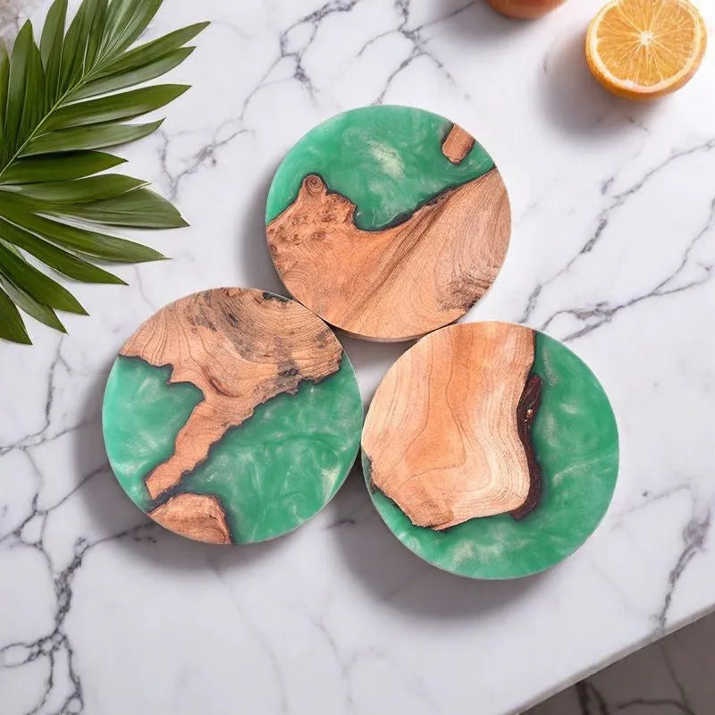 Set of solid wood coasters for tea, showing round green and black versions on a wooden table.