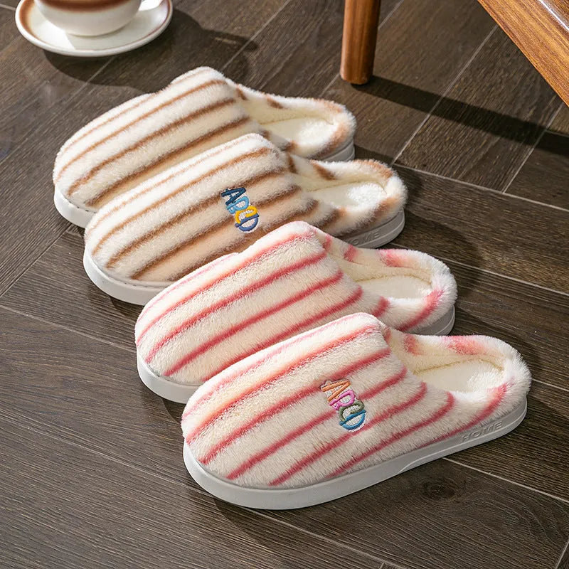 A pair of colourful vertically striped cotton flip flop slippers for adults on a plain background.