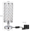 Modern crystal table lamp with gold metal base and hollow-carved crystal shade on a bedside table