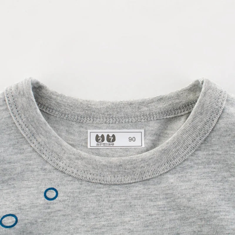 Grey cotton children's t-shirt laid flat, showing Asian size tags for 90cm, 100cm, 110cm, 120cm, 130cm, and 140cm lengths.