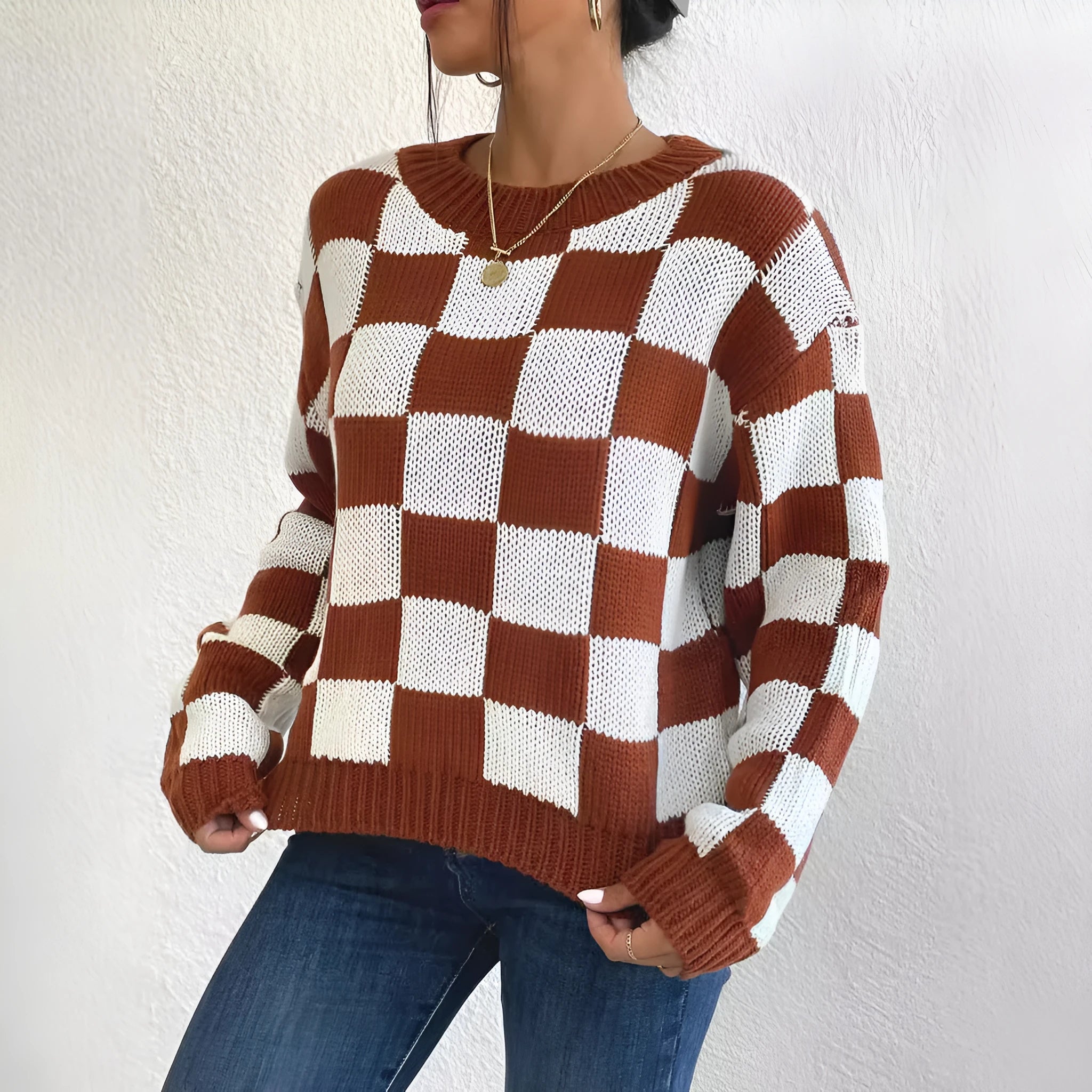 Dark brown loose-fit pullover sweater with a plaid chessboard pattern and long sleeves.