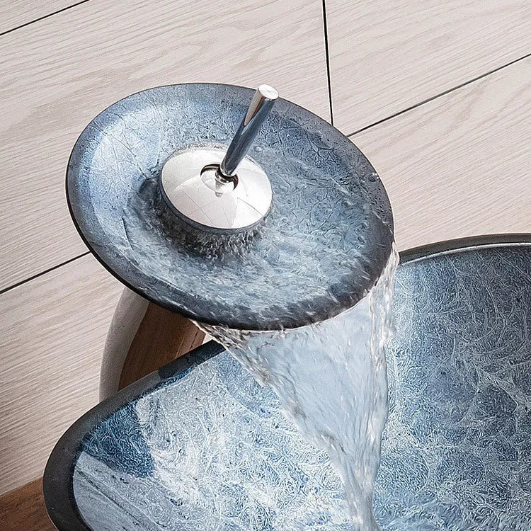 Blue grey coloured tempered glass bathroom table basin with simple art design on a countertop.