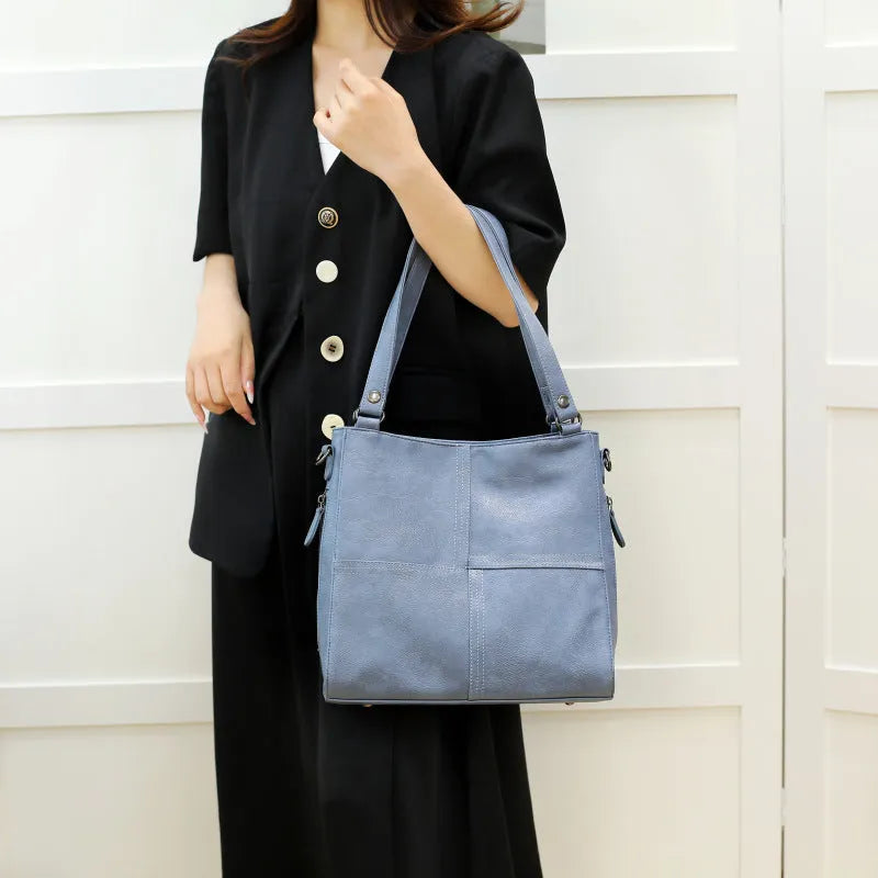 Soft PU leather crossbody handbag with barrel shape and vintage styling in light khaki colour