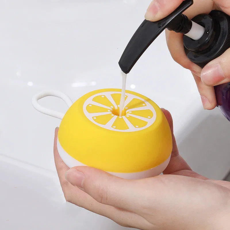 Yellow silicone pet bath brush with massage bristles and comb teeth on a blue background.