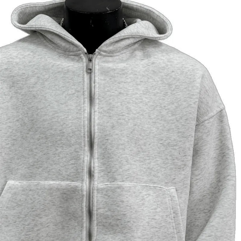 Man wearing a light gray hooded coat with a schoolbag design detail on the back.