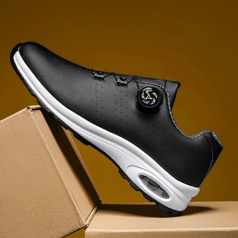 Black and white low-top tennis shoes with mesh upper and cross-shoulder straps on a composite sole.
