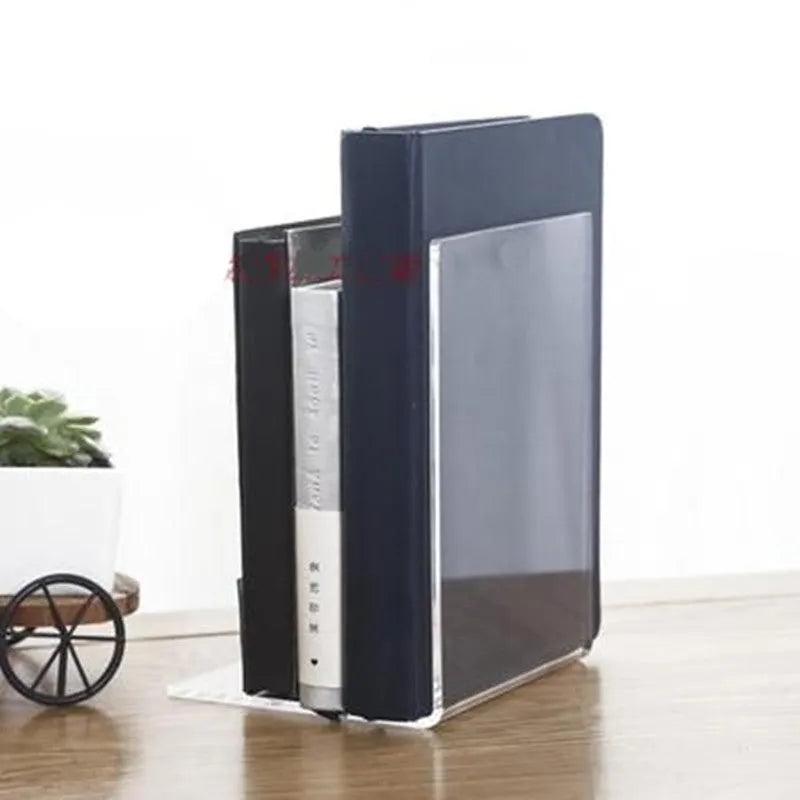 Transparent acrylic bookshelf display rack on a desk holding two books.
