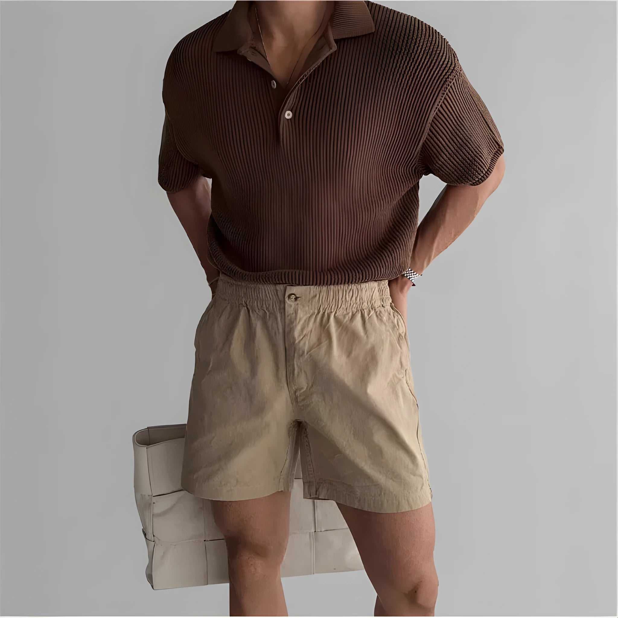 A pair of loose-fitting cotton sports shorts in khaki colour on a white background.