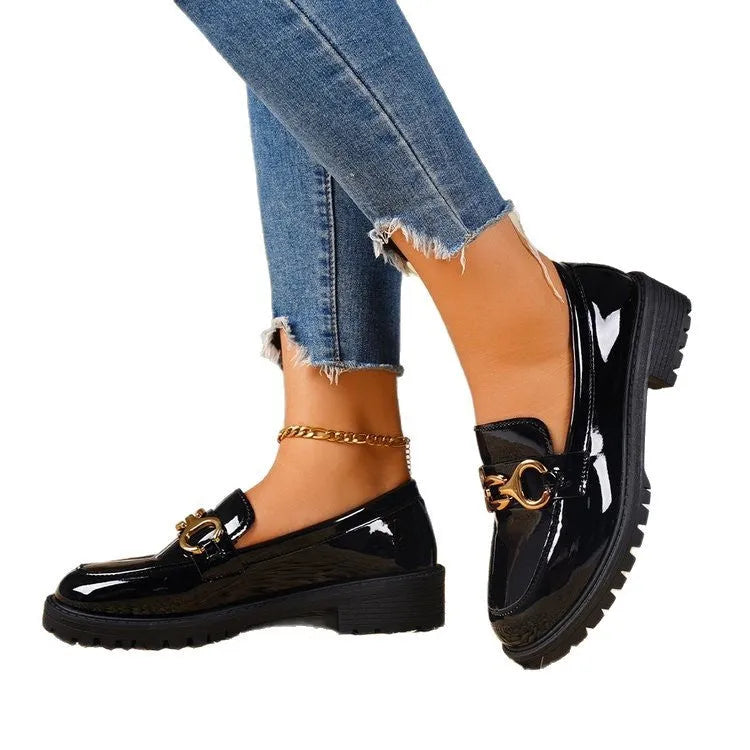 Black women's chunky heel round toe pumps with a thick rubber sole and metal detail on a white background.