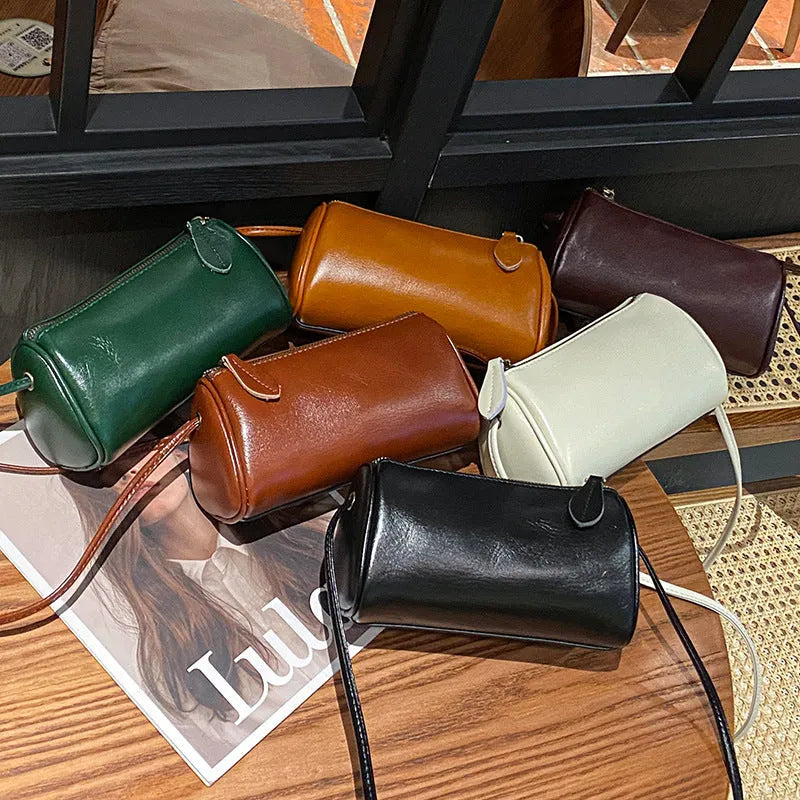 Genuine first layer cowhide crossbody bag in cylinder shape with sewing line details, available in six colours