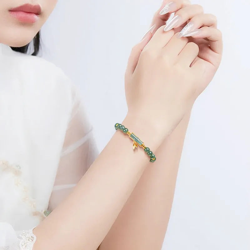 Women's silver bracelet with blue jade beads on a white background.